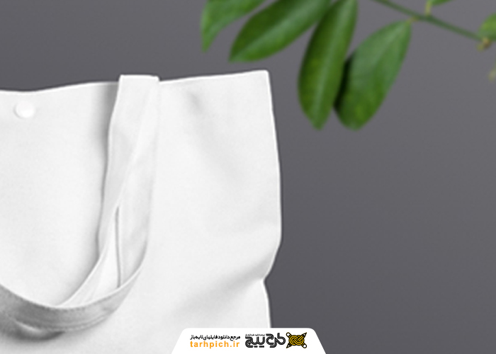 دانلود موکاپ ساک خرید پارچه ای دکمه دار در کنار گیاه