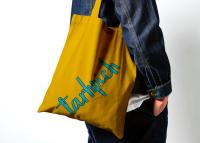 دانلود موکاپ کیف و ساک خرید پارچه‌ای در دست فرد از نمای نزدیک