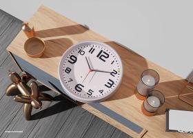 دانلود موکاپ ساعت دیواری روی میز چوبی با شمع و مجسمه
